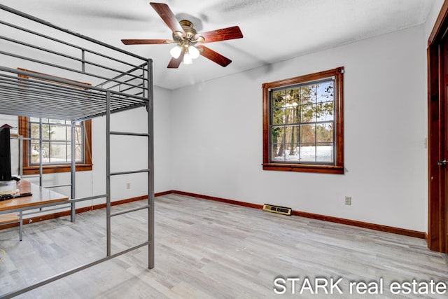 unfurnished bedroom featuring a closet, light hardwood / wood-style flooring, and ceiling fan