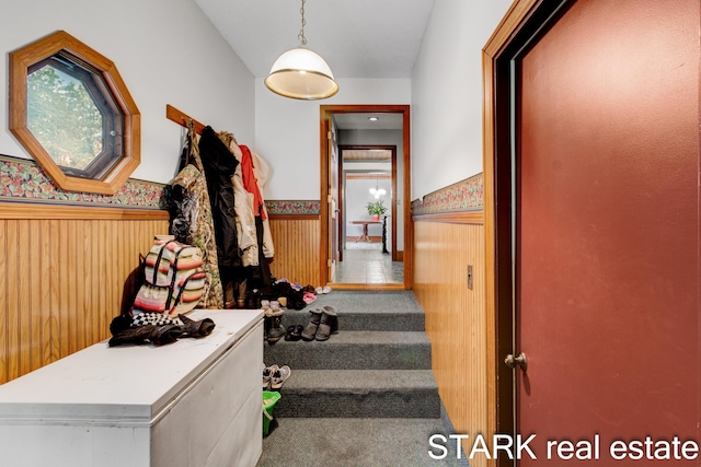 hall featuring carpet flooring and wood walls