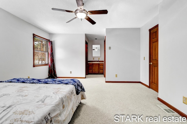 bedroom with ensuite bath, ceiling fan, sink, and light carpet