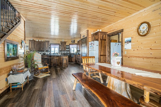 dining room with dark hardwood / wood-style flooring, wooden walls, and wooden ceiling