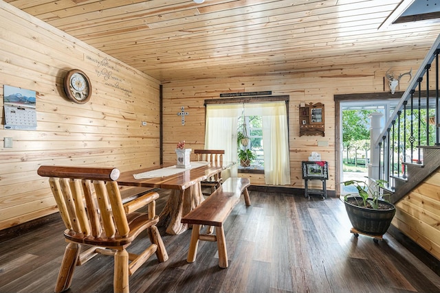 dining room with wooden ceiling, dark wood-type flooring, and wooden walls