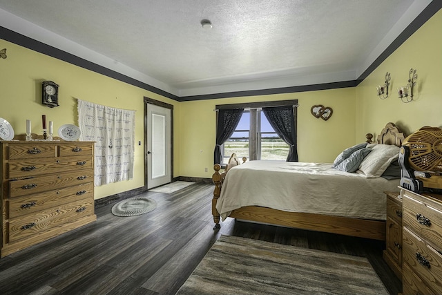 bedroom with access to exterior, a textured ceiling, and dark hardwood / wood-style flooring