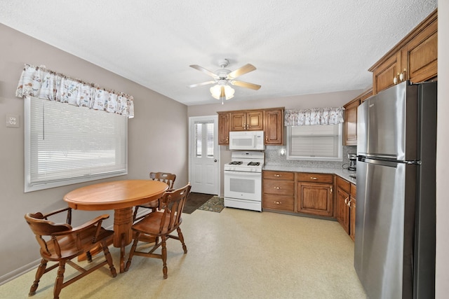 kitchen with a textured ceiling, white appliances, ceiling fan, and backsplash