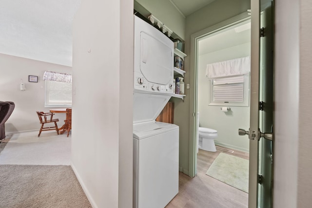 washroom with light carpet and stacked washer / drying machine