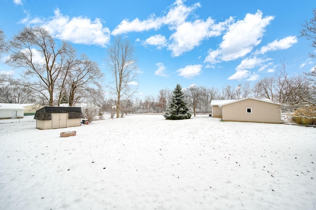 snowy yard with a storage shed