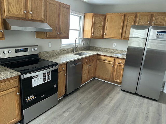 kitchen featuring light stone countertops, sink, light wood-type flooring, and appliances with stainless steel finishes