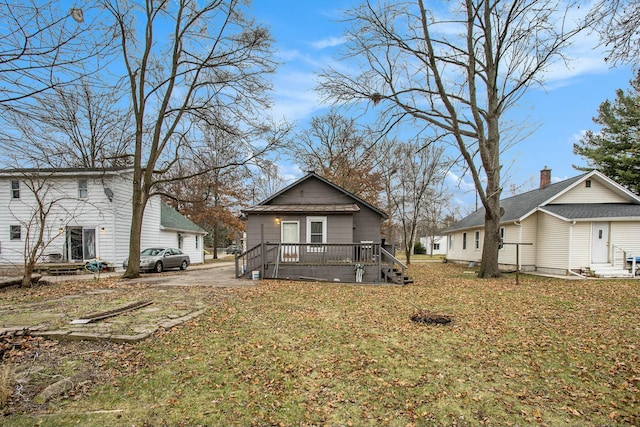 back of property with a yard and a deck