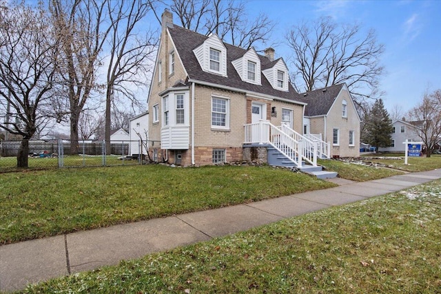 cape cod home featuring a front lawn