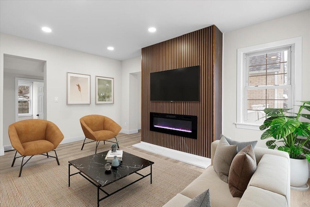 living room with a fireplace and light wood-type flooring