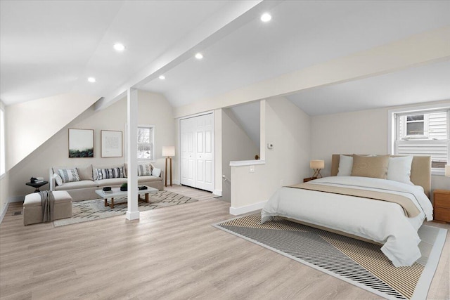 bedroom featuring vaulted ceiling with beams, light hardwood / wood-style floors, and a closet