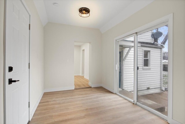 interior space featuring lofted ceiling and light hardwood / wood-style flooring