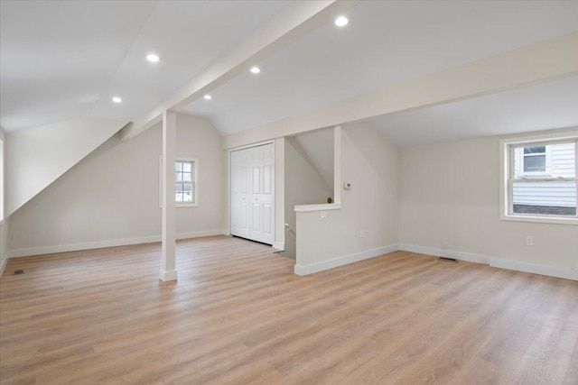 bonus room featuring lofted ceiling with beams and light hardwood / wood-style floors