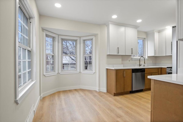 kitchen with light hardwood / wood-style floors, white cabinetry, sink, and appliances with stainless steel finishes