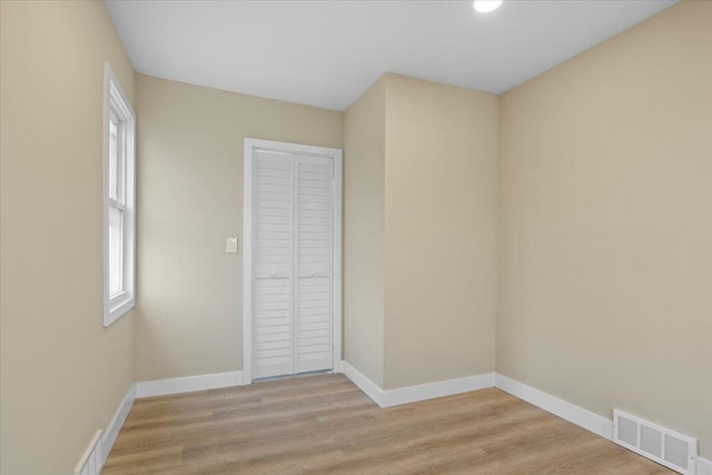 unfurnished bedroom with a closet and light wood-type flooring