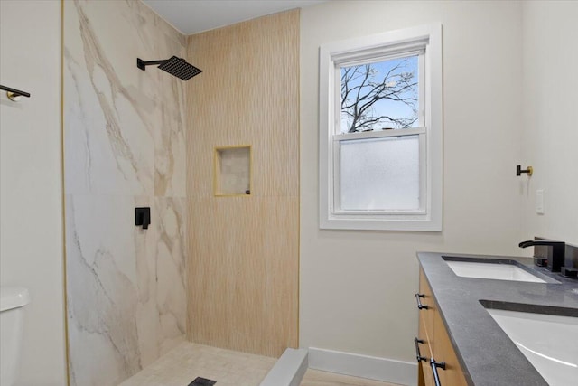 bathroom featuring toilet, vanity, and tiled shower