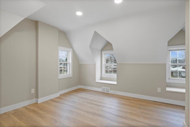 additional living space featuring lofted ceiling and light wood-type flooring