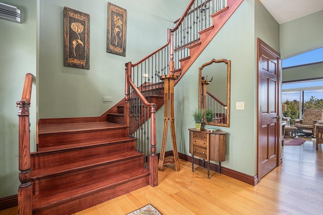 stairway with hardwood / wood-style flooring and a wall mounted AC