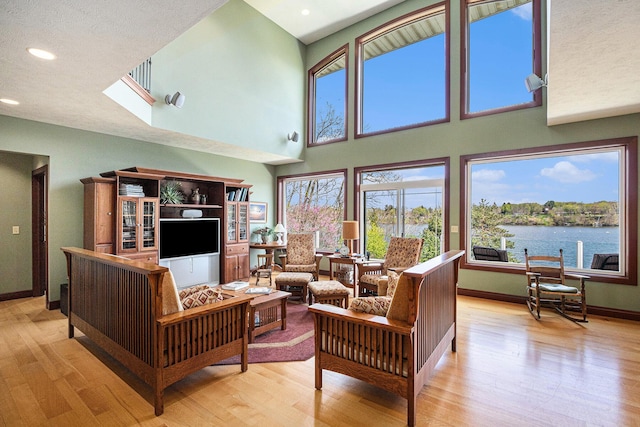 living room with a high ceiling and light wood-type flooring