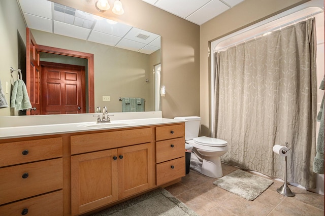 bathroom with a shower with shower curtain, vanity, a drop ceiling, and toilet