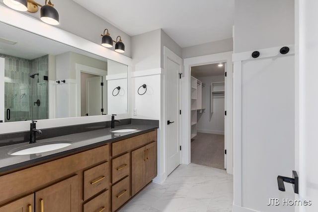 full bath featuring marble finish floor, a sink, a shower stall, and a spacious closet