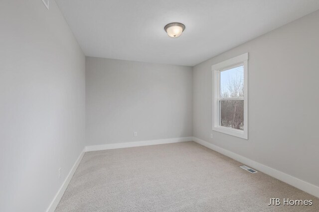 unfurnished room featuring carpet floors, visible vents, and baseboards