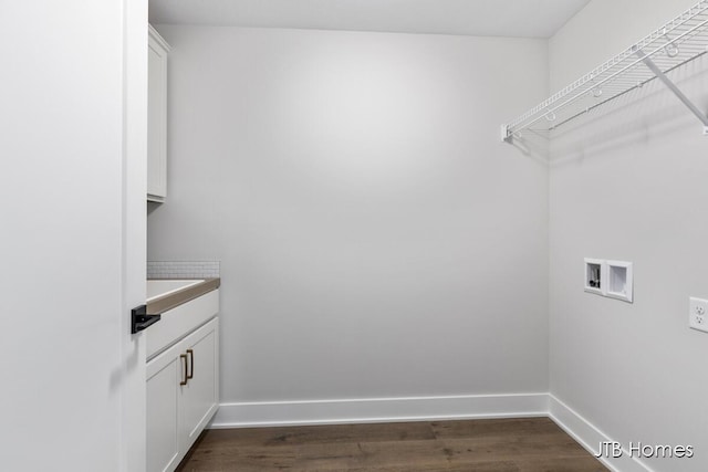 laundry room featuring dark wood-type flooring, hookup for a washing machine, cabinet space, and baseboards