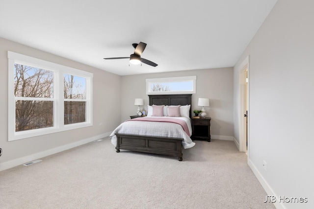 bedroom featuring carpet floors, visible vents, multiple windows, and baseboards