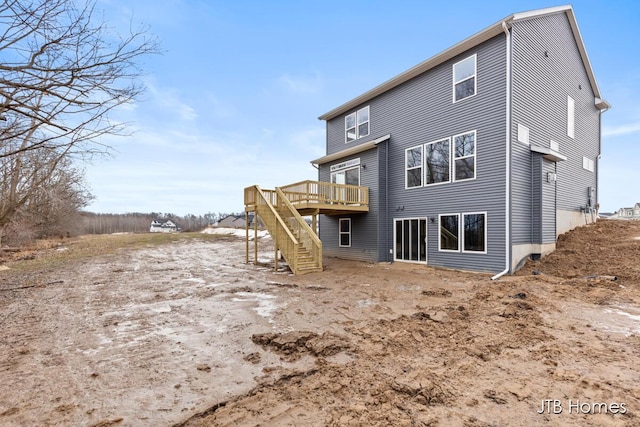 back of house featuring stairway and a deck