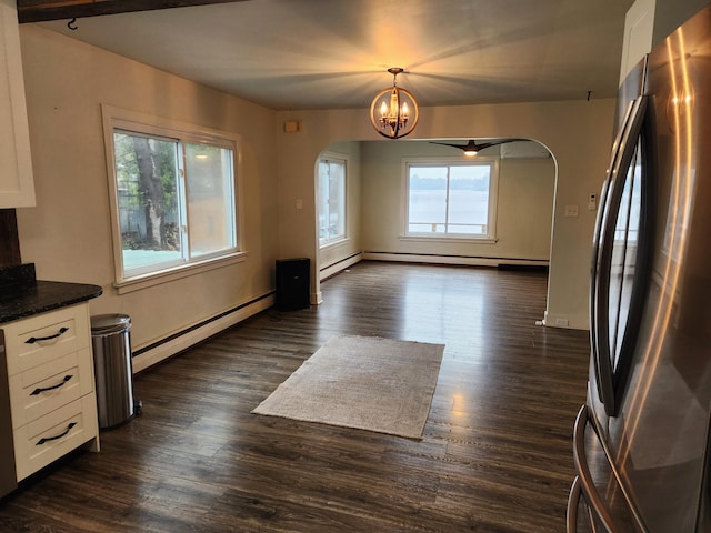 9318 School St, Lake, MI 48632 - unfurnished dining area with arched walkways, a baseboard radiator, dark wood finished floors, and a chandelier