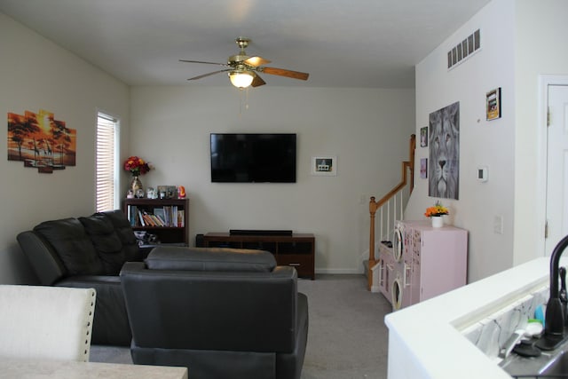 carpeted living room with ceiling fan