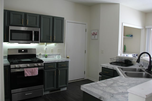 kitchen with sink, appliances with stainless steel finishes, and dark wood-type flooring