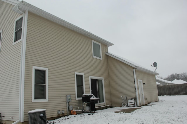 snow covered property featuring central AC unit