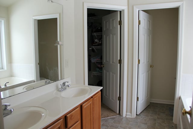 bathroom with vanity and a bath