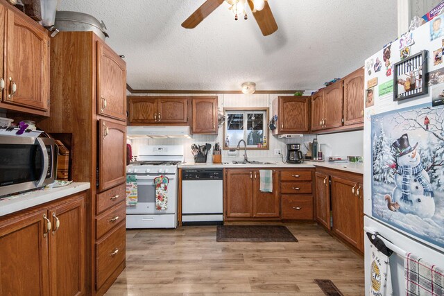 kitchen with ceiling fan, sink, light hardwood / wood-style flooring, a textured ceiling, and white appliances