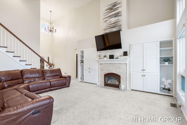 living room featuring light carpet, a high ceiling, and a healthy amount of sunlight