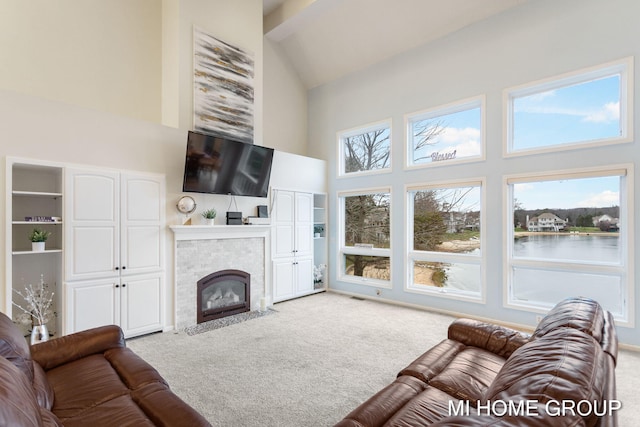 living room featuring a tile fireplace, light carpet, and high vaulted ceiling