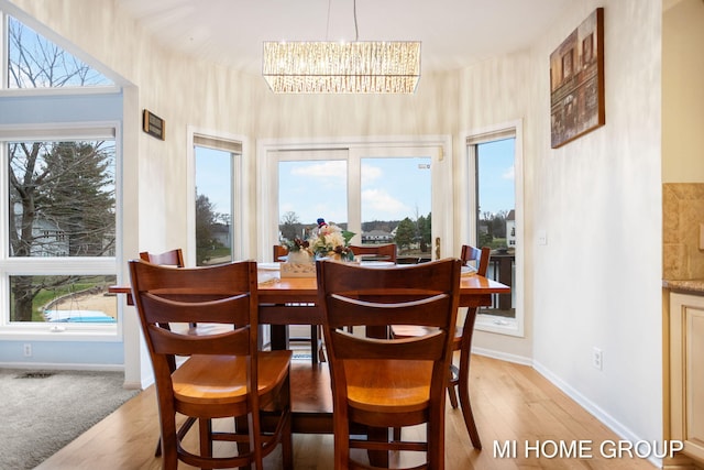 dining area featuring a chandelier, a healthy amount of sunlight, and light hardwood / wood-style flooring