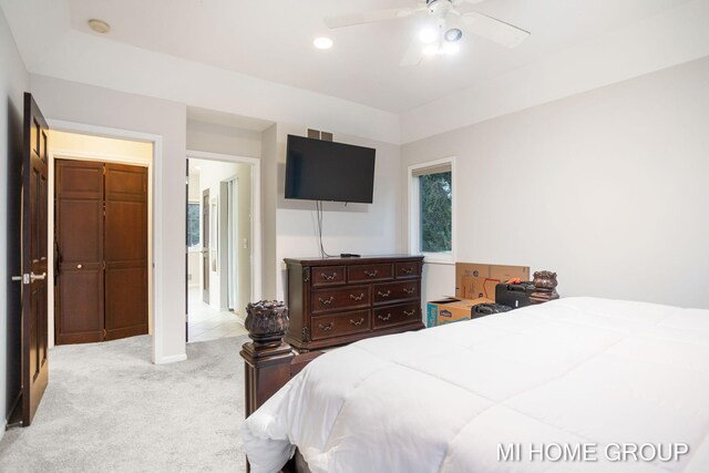 bedroom with ceiling fan, light carpet, and a closet