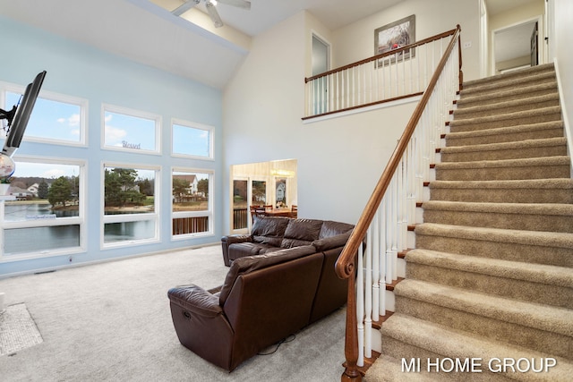 living room featuring carpet, a high ceiling, and ceiling fan