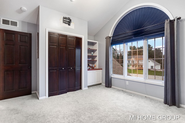 unfurnished bedroom with light colored carpet and a closet