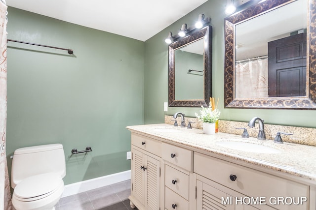 bathroom with tile patterned flooring, vanity, and toilet