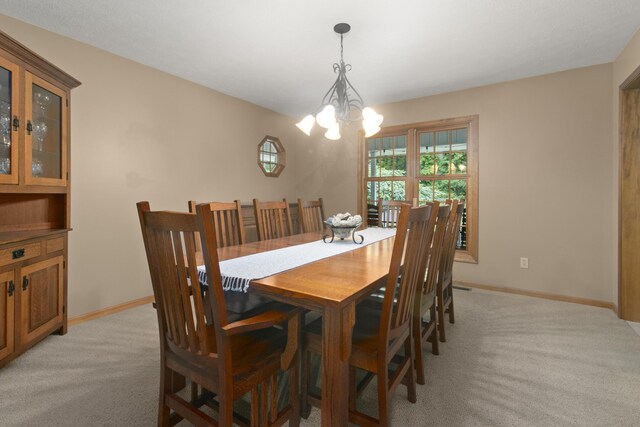 dining area featuring light carpet and a chandelier