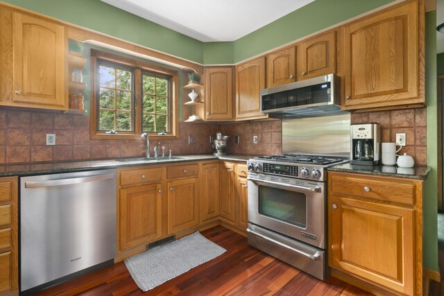 kitchen featuring decorative backsplash, appliances with stainless steel finishes, dark hardwood / wood-style floors, and sink