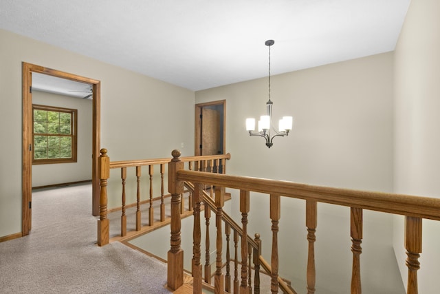 staircase with carpet flooring and a chandelier