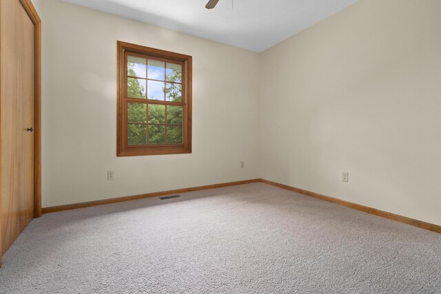 empty room featuring carpet flooring and ceiling fan