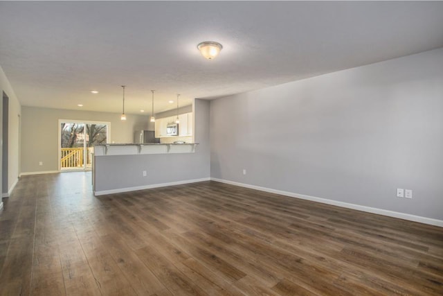 unfurnished living room with dark hardwood / wood-style flooring