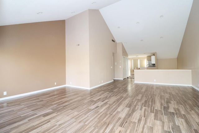 unfurnished living room with light hardwood / wood-style flooring and lofted ceiling