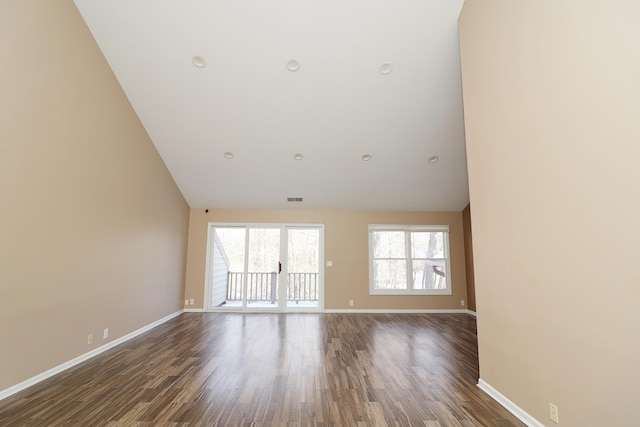 unfurnished room with dark wood-type flooring and lofted ceiling