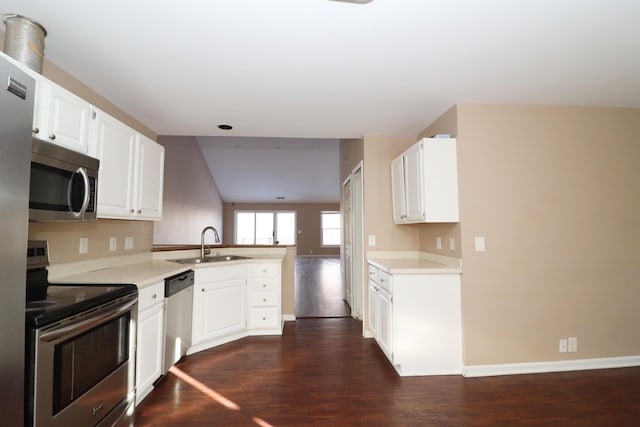 kitchen featuring kitchen peninsula, dark hardwood / wood-style flooring, stainless steel appliances, sink, and white cabinets