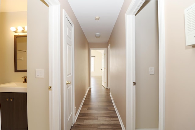 corridor featuring dark wood-type flooring and sink